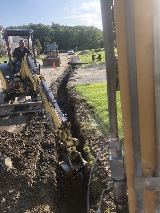 a man is driving an excavator on a dirt road .