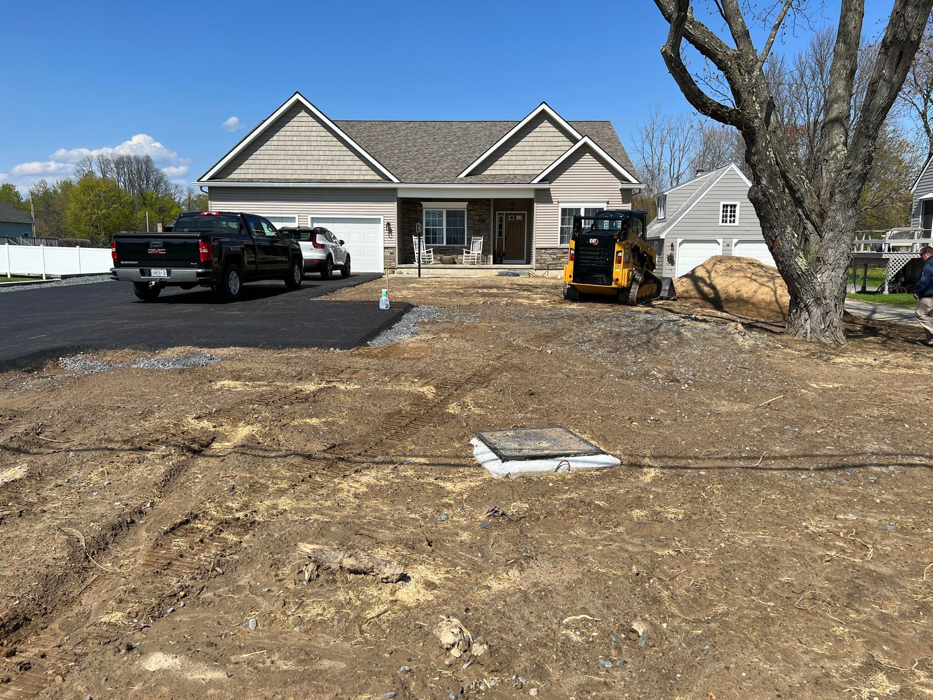 a truck and a bulldozer are parked in front of a house .