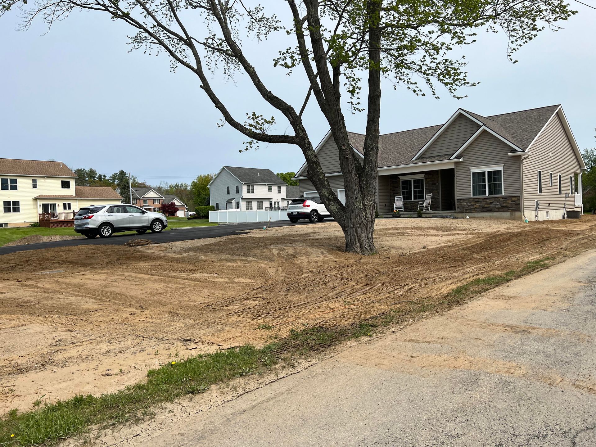 a house is being built in a residential area with cars parked in front of it .