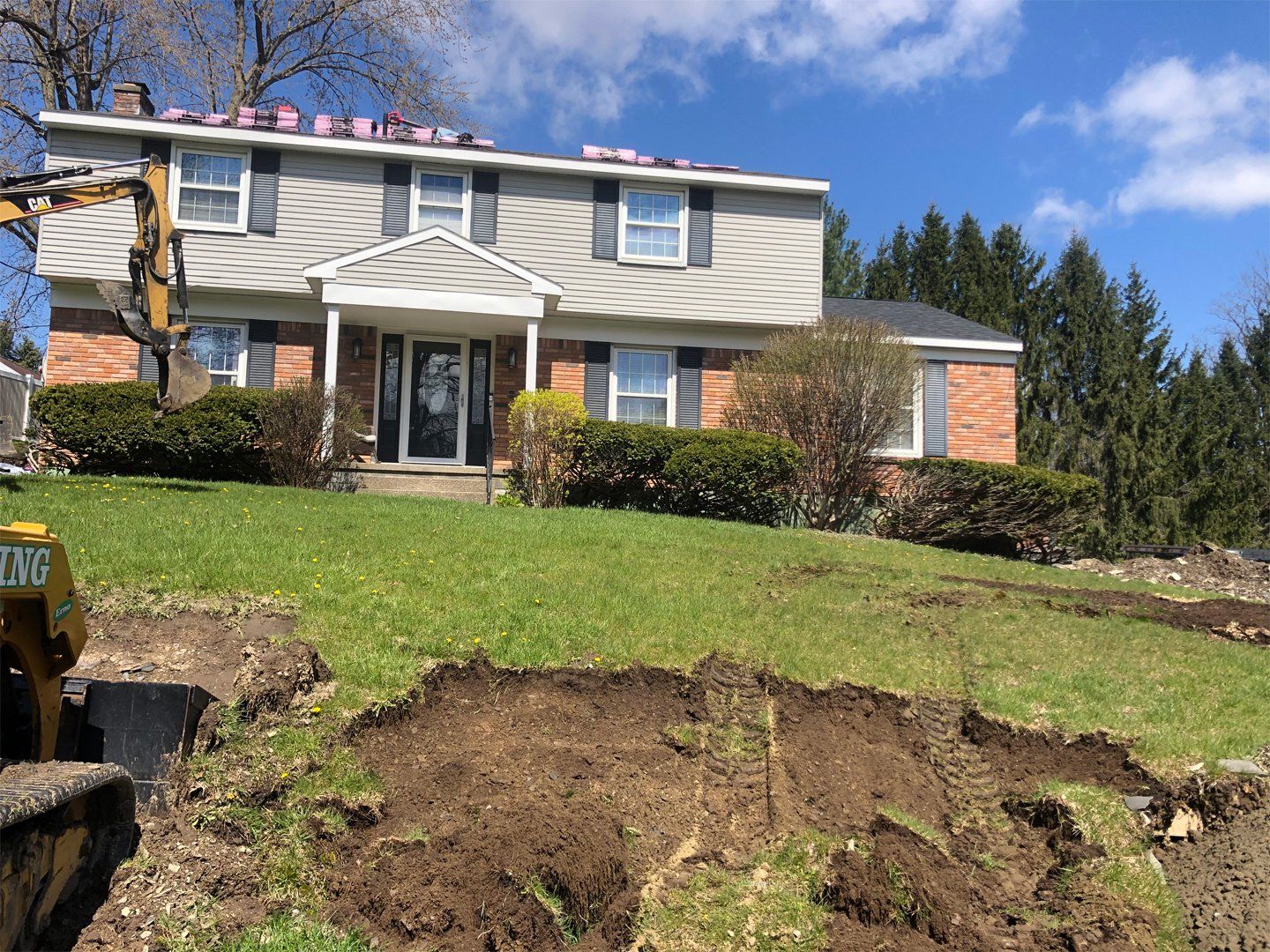 a large house with a yellow excavator in front of it .