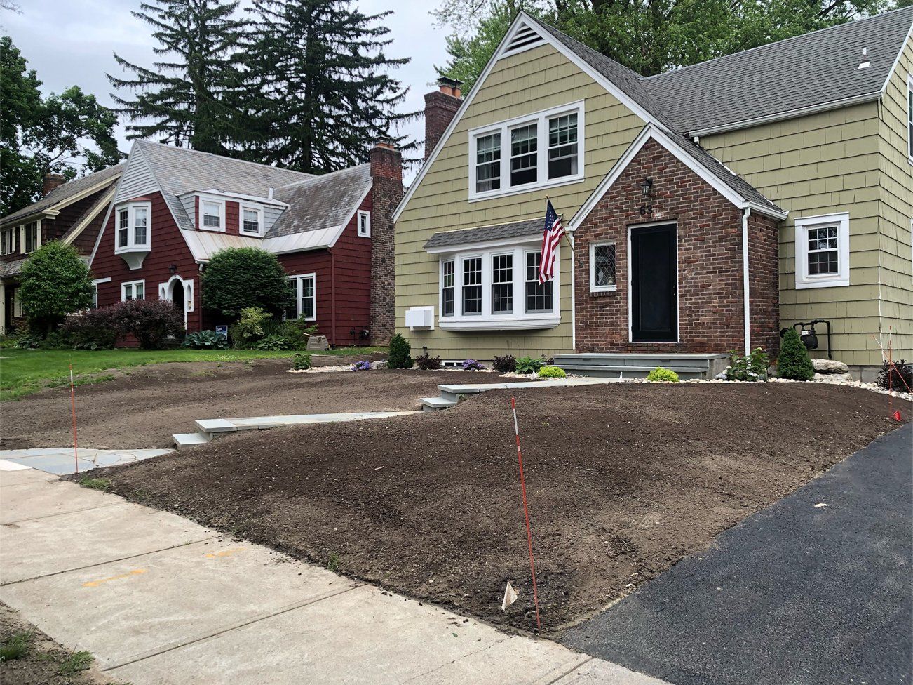 a brick house with a green siding is next to a red house .