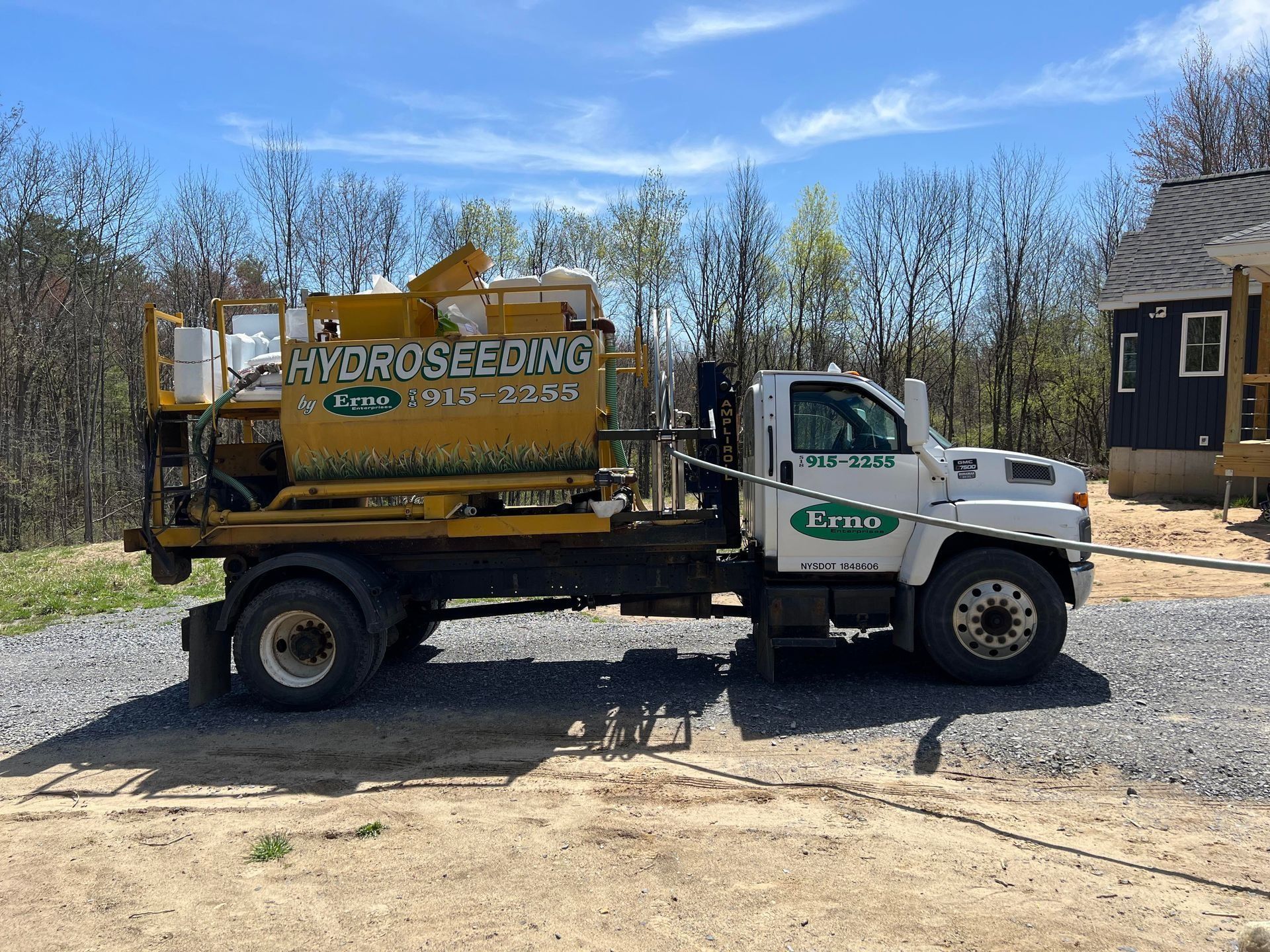 Erno hydroseeding truck is parked in front of a house .