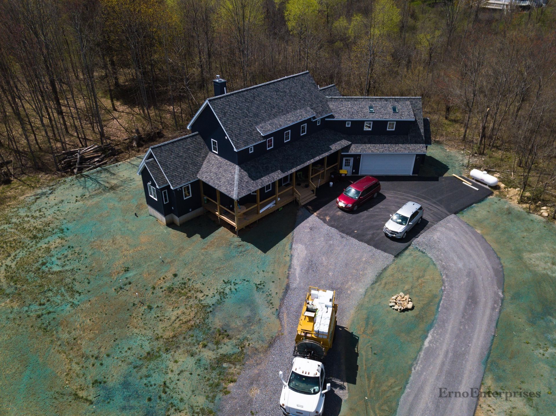 an aerial view of a large house with a freshly hydroseeded yard.