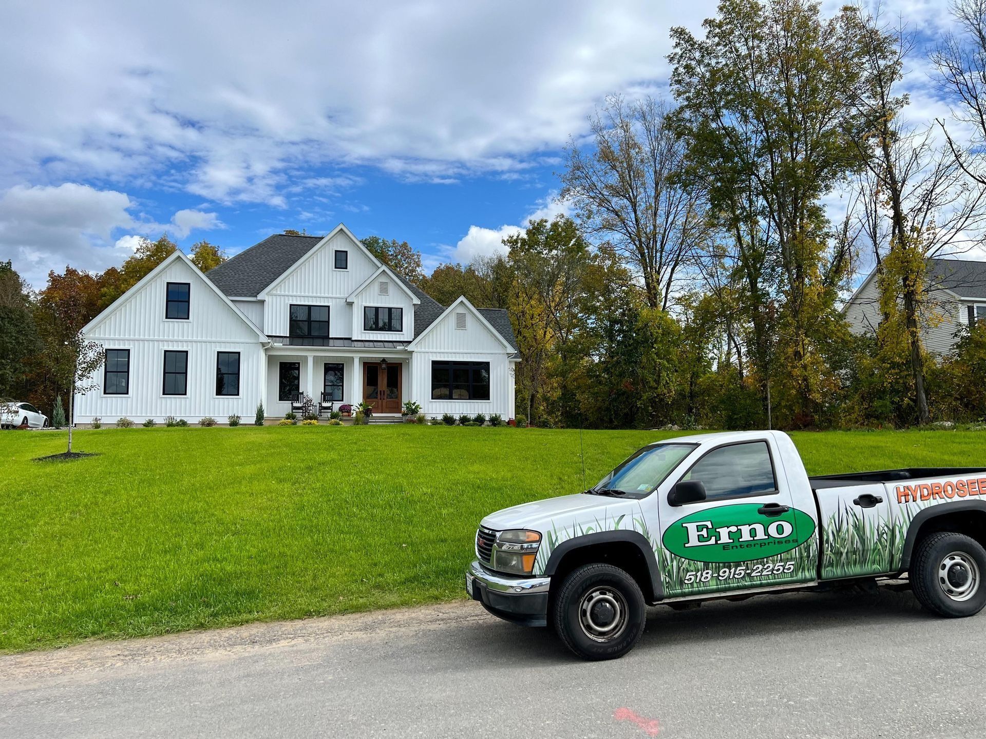 Erno pickup truck is parked in front of a large white house .