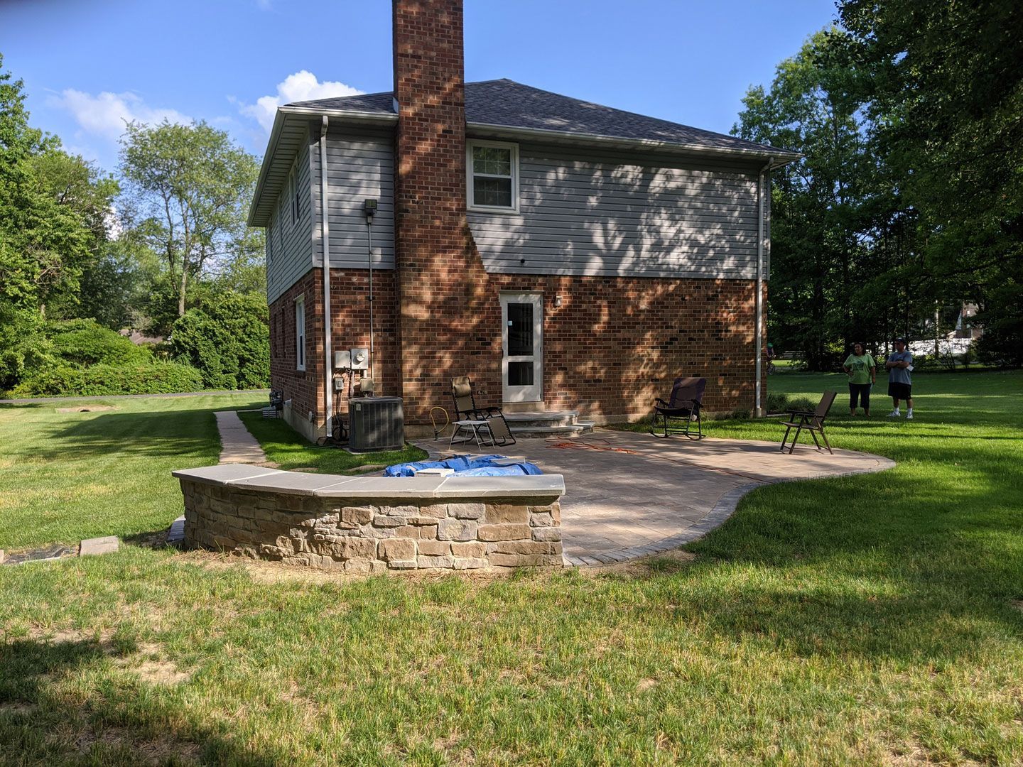 A brick house with a patio and a fire pit in front of it.