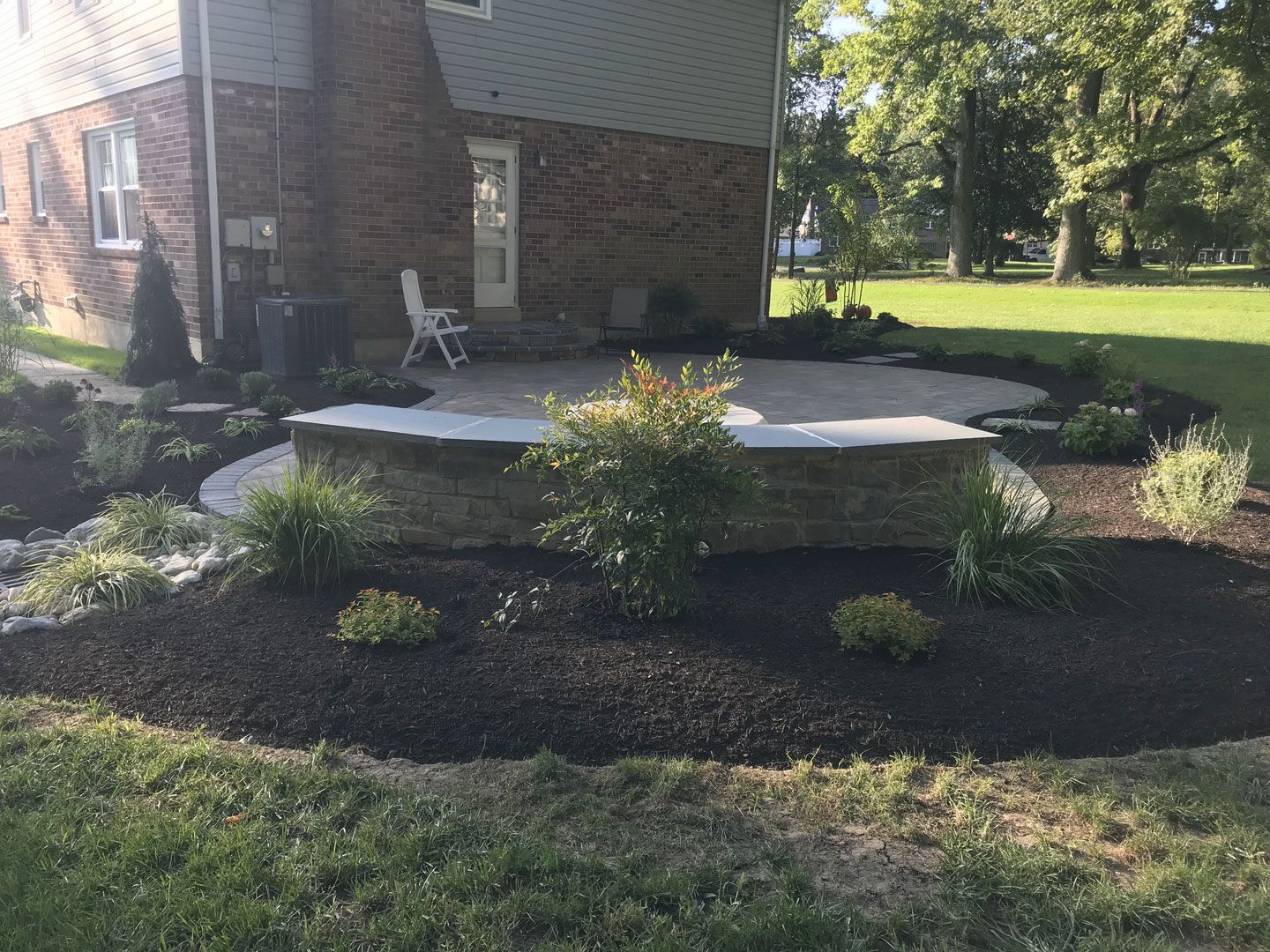 A brick house with a patio in front of it.
