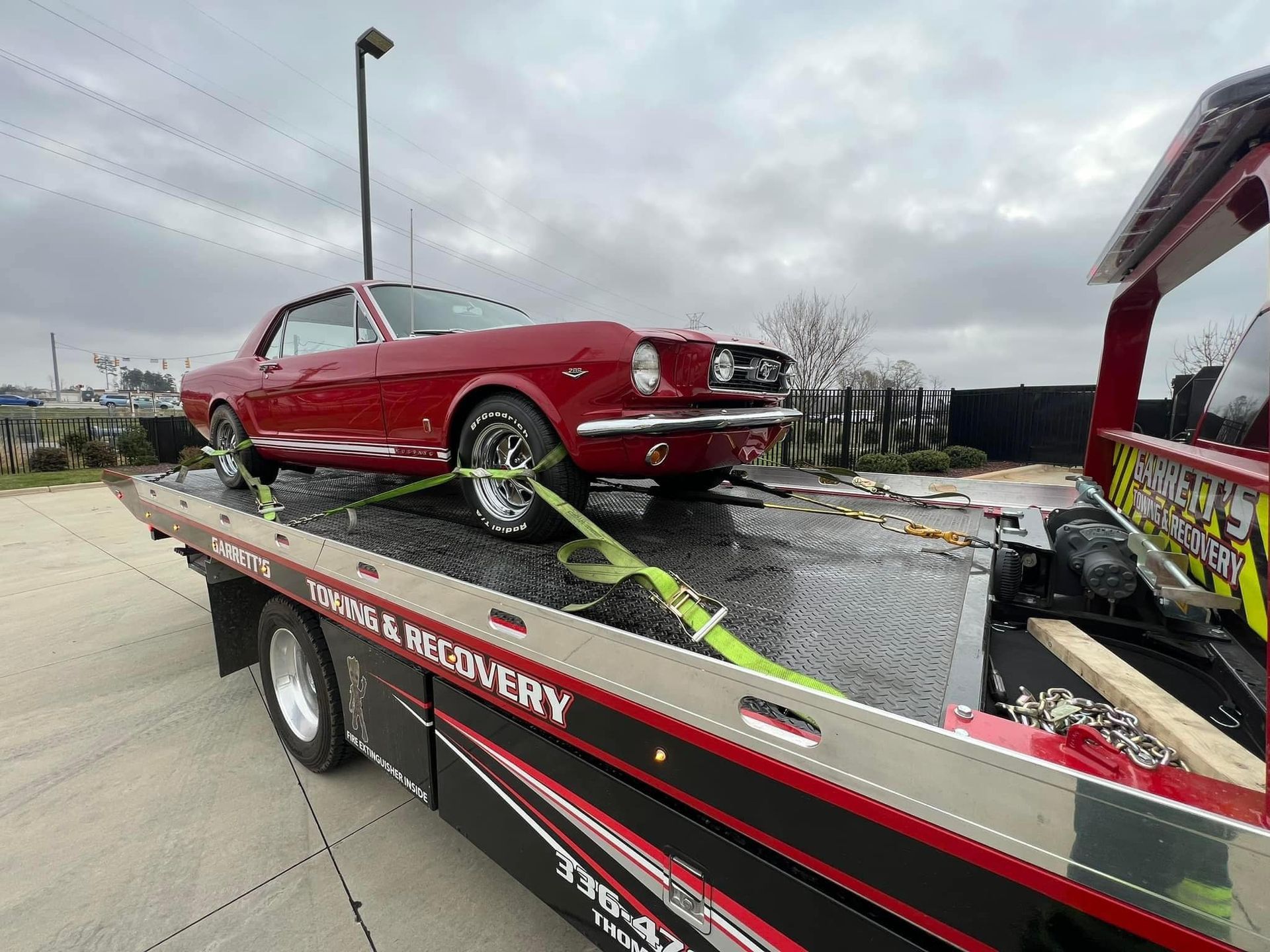 Equipment display: yellow lifting straps, chains, hooks, and safety gear on a wall.