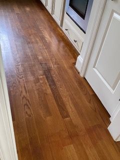 A kitchen with hardwood floors and white cabinets.