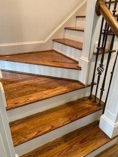 A close up of a wooden staircase with a white railing.