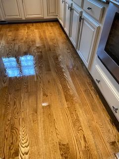 A kitchen with hardwood floors and white cabinets.
