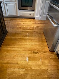 A kitchen with hardwood floors and stainless steel appliances.