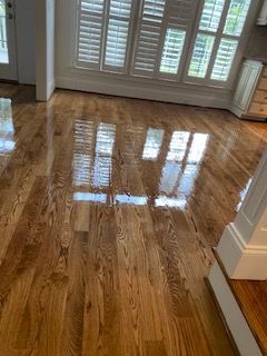 A living room with hardwood floors and shutters on the windows.