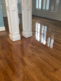 A living room with hardwood floors and white columns.