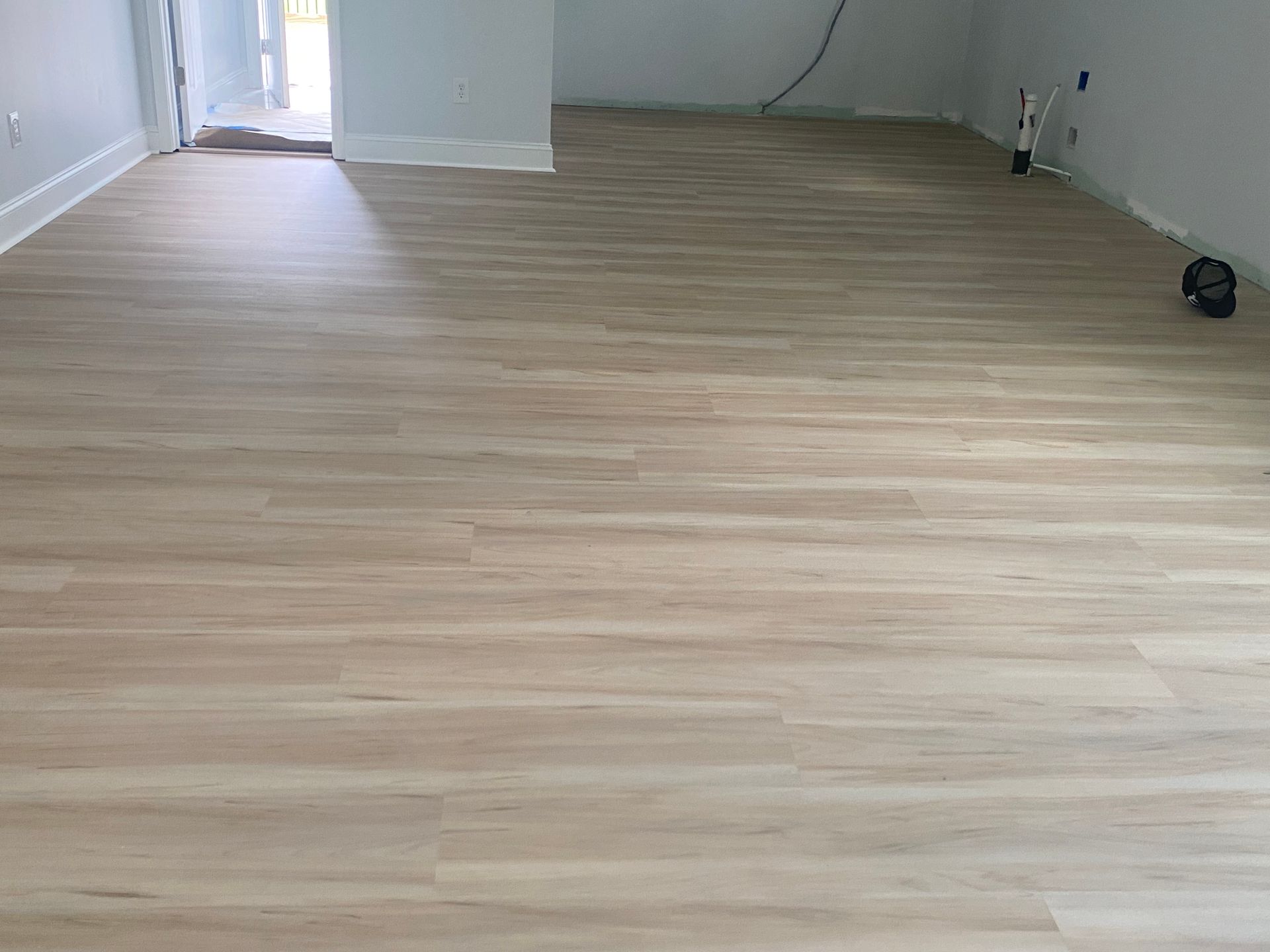 A living room with a wooden floor and white walls.