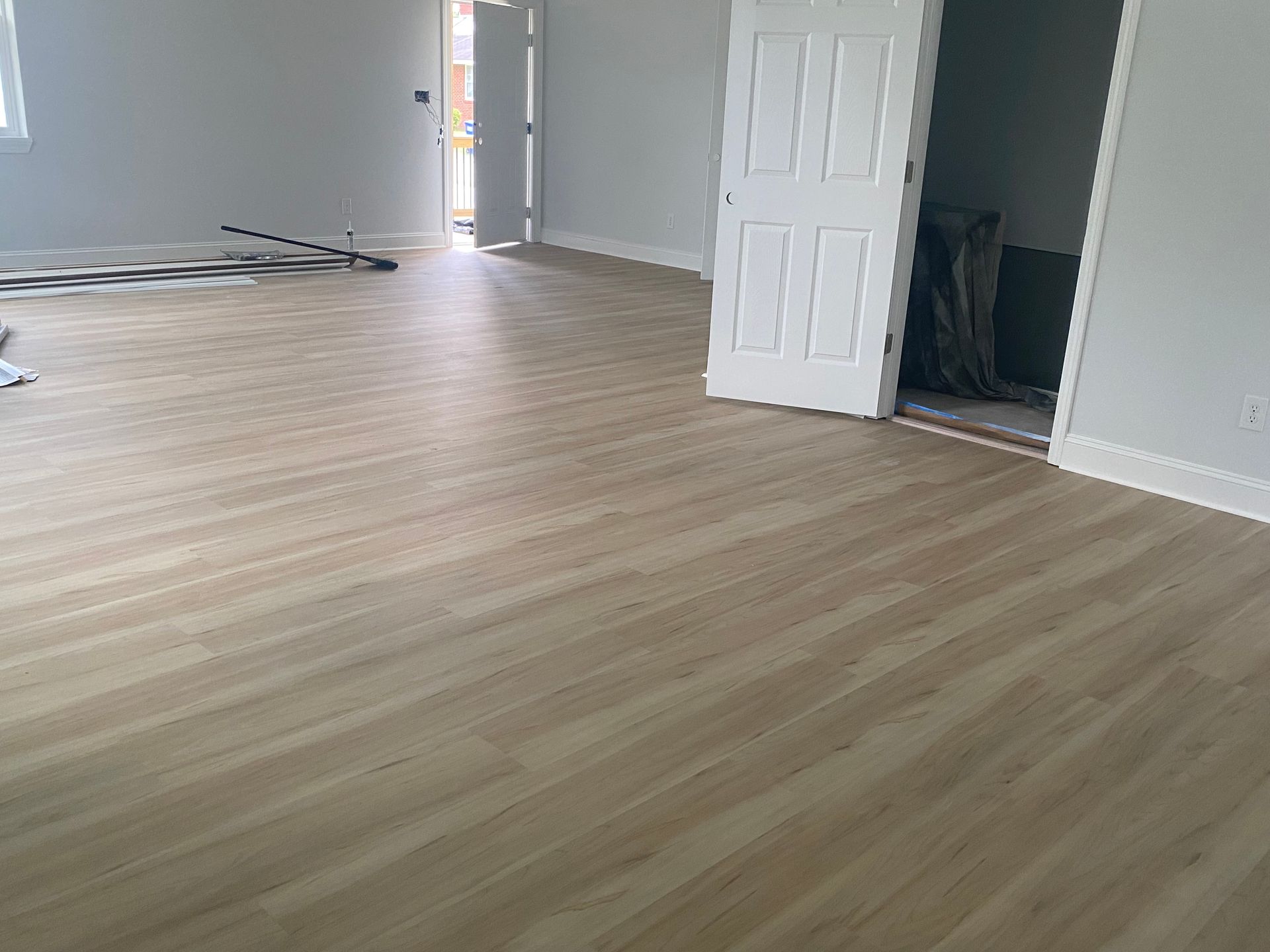 A large room with a wooden floor and a door.