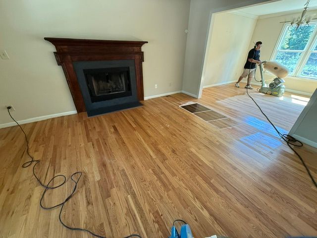 A living room with hardwood floors and a fireplace.