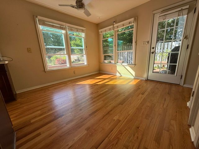 A living room with hardwood floors and a ceiling fan.
