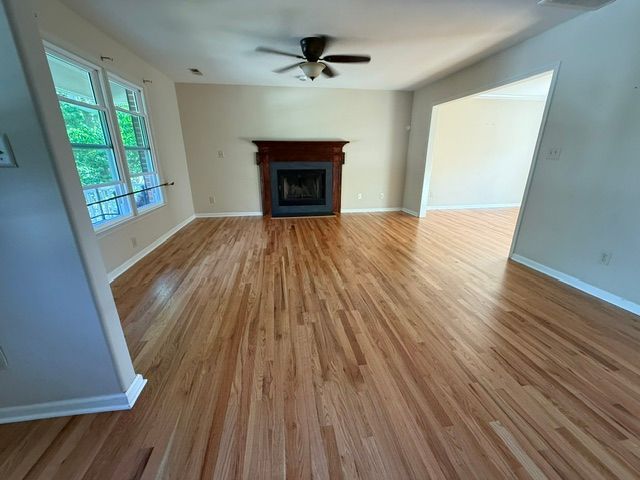 A living room with hardwood floors and a fireplace.