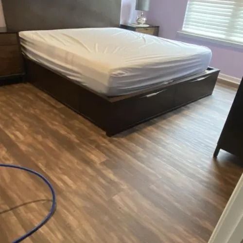 A bed is sitting on a wooden floor in a bedroom.