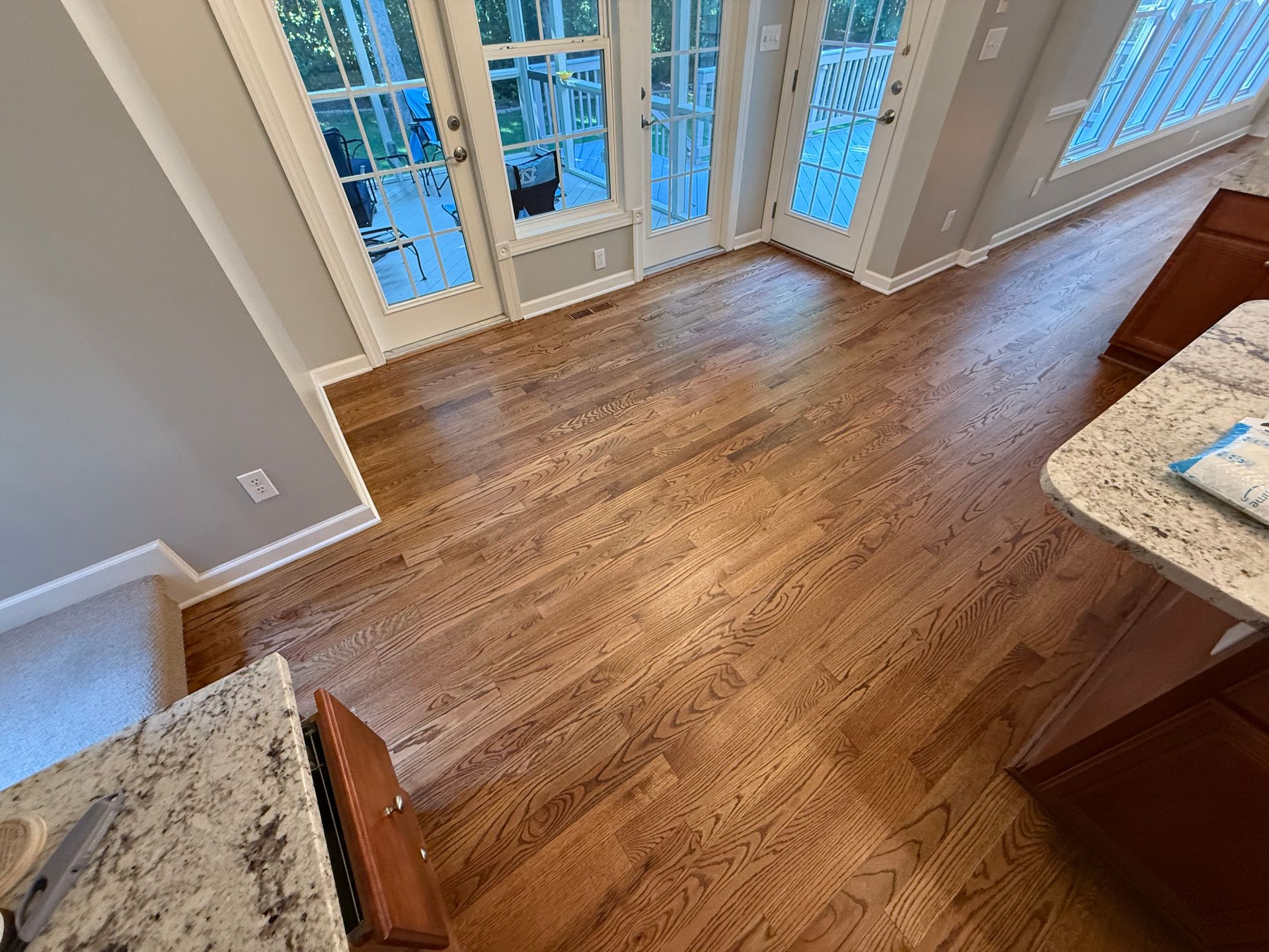 A kitchen with hardwood floors and sliding glass doors.