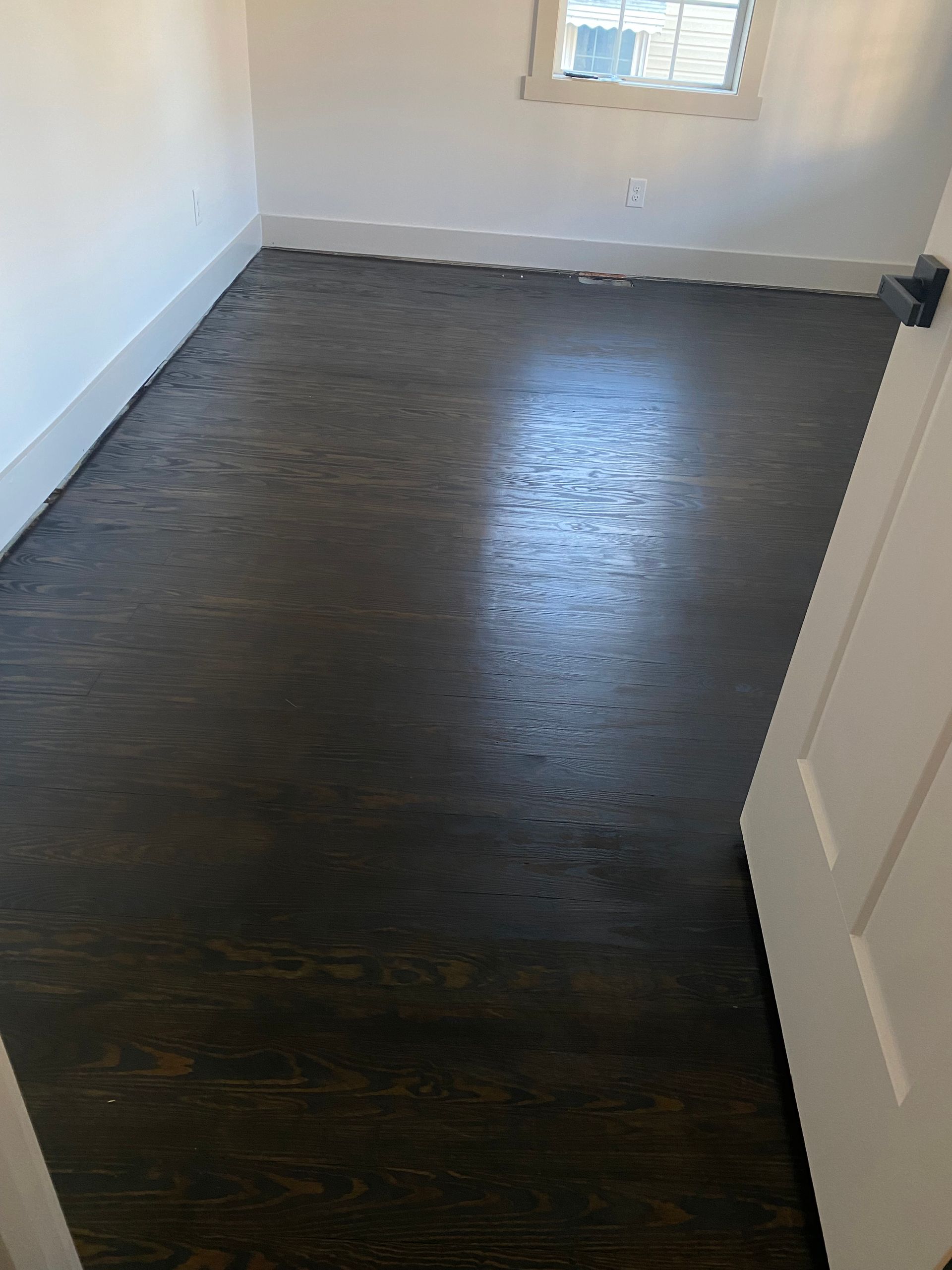 A room with a wooden floor and a window.