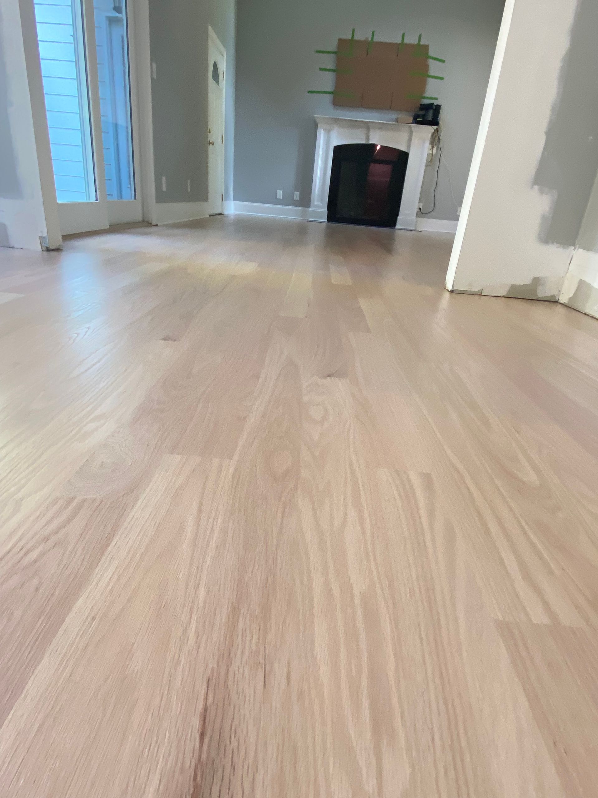 A living room with a wooden floor and a fireplace.