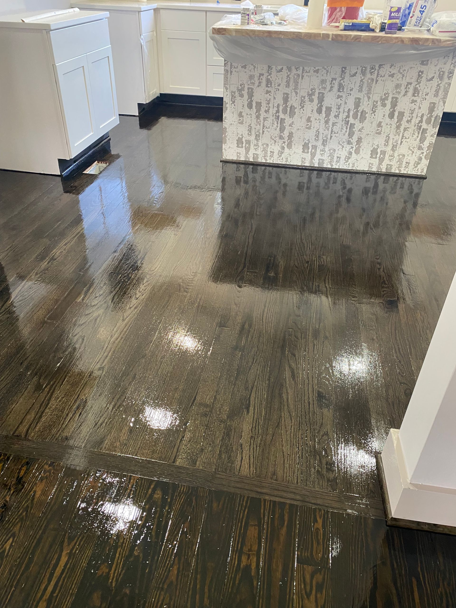 A kitchen with a wooden floor and a white counter top.