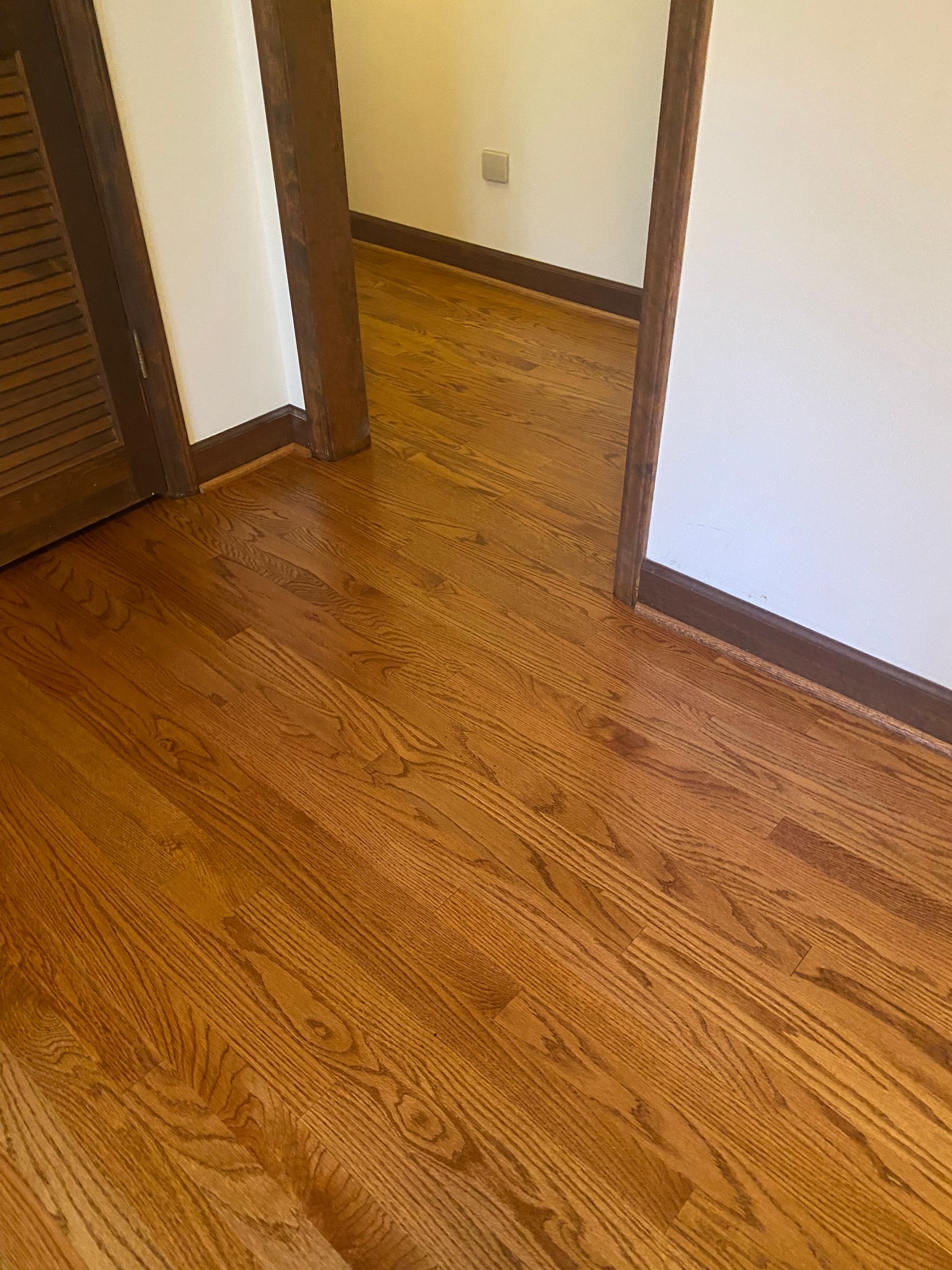 A hallway with hardwood floors and white walls.