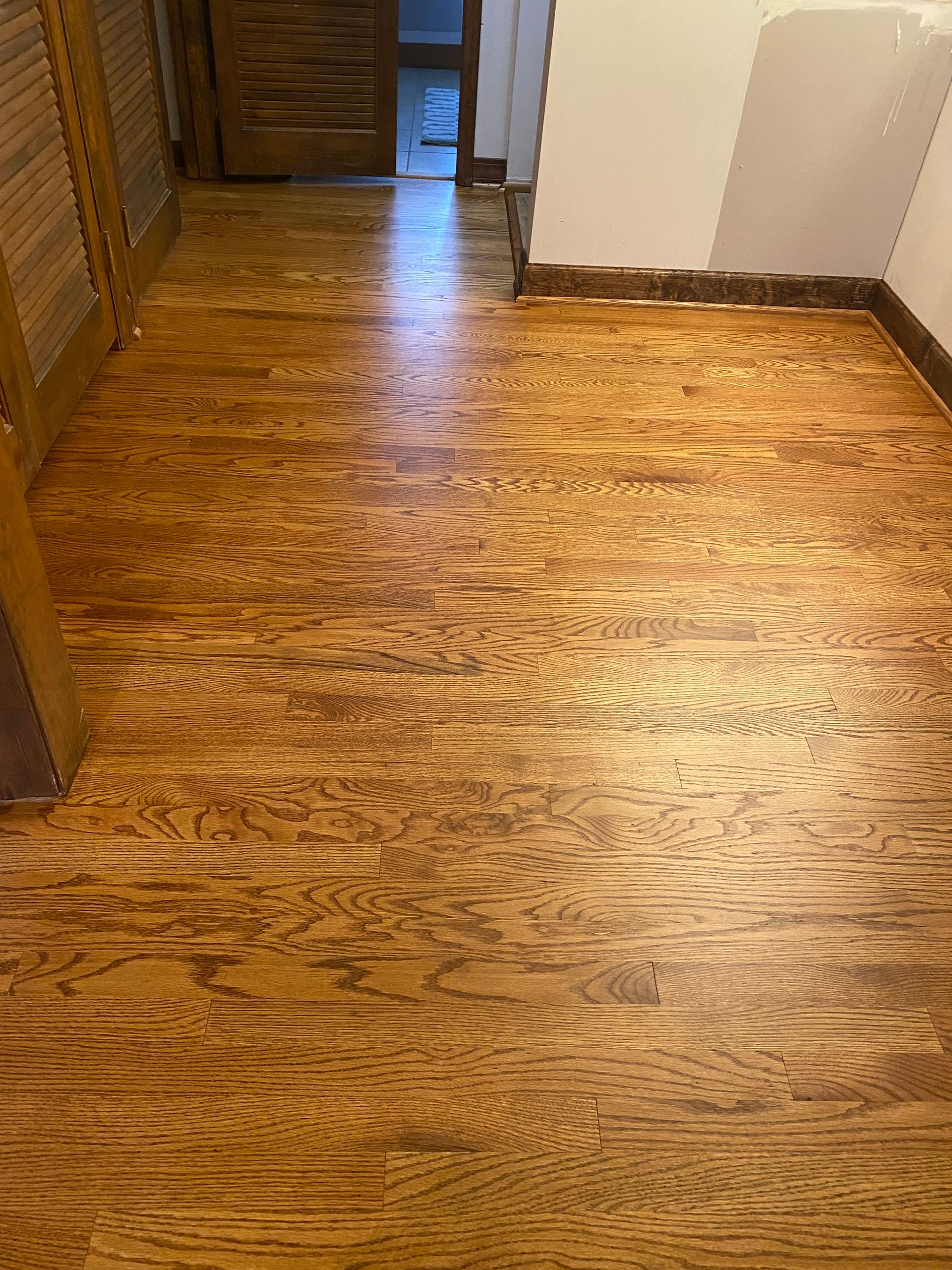 A wooden floor in a room with a door.