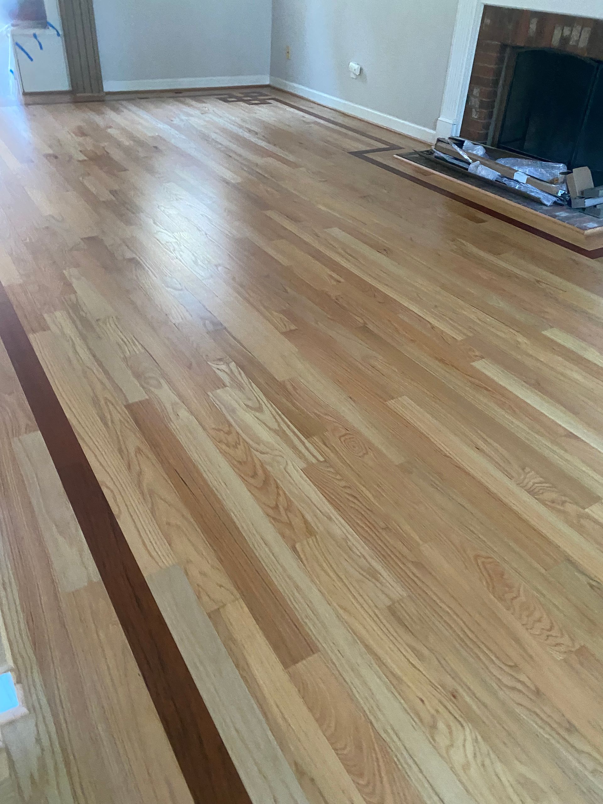 A living room with hardwood floors and a fireplace.