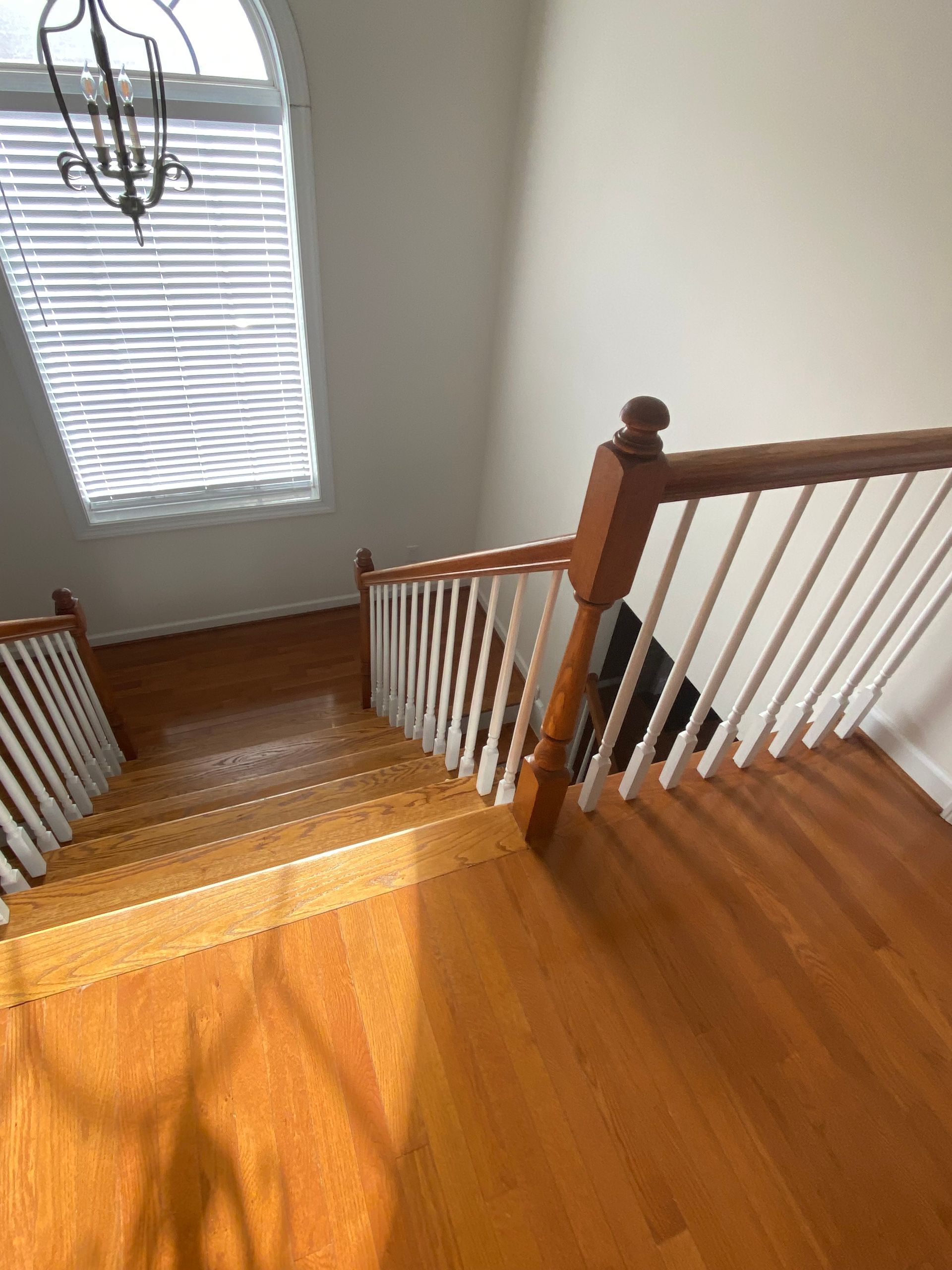 A wooden staircase with a white railing and a window.