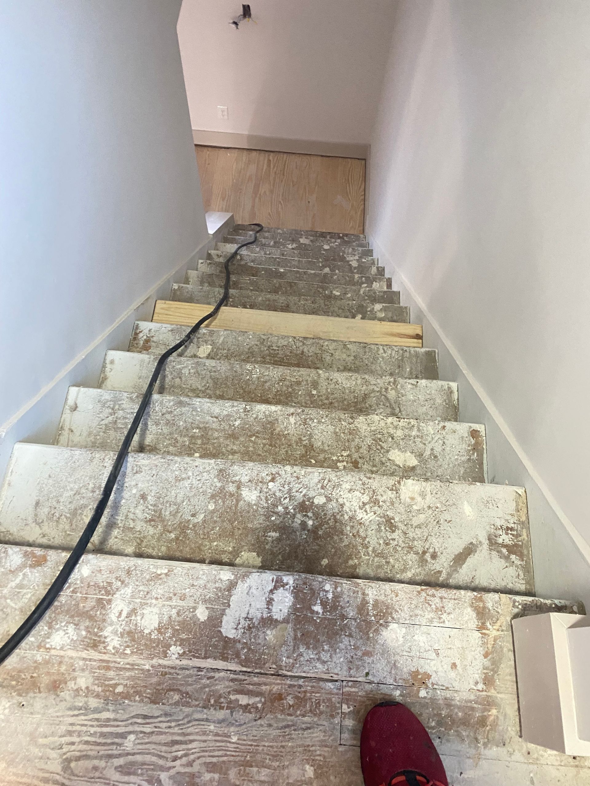 A person is standing on a set of stairs that are being remodeled.