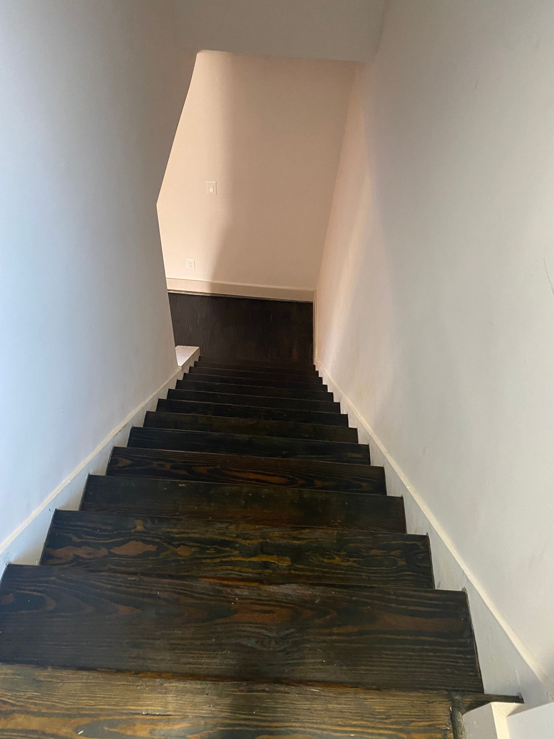 A set of wooden stairs leading up to the second floor of a house.