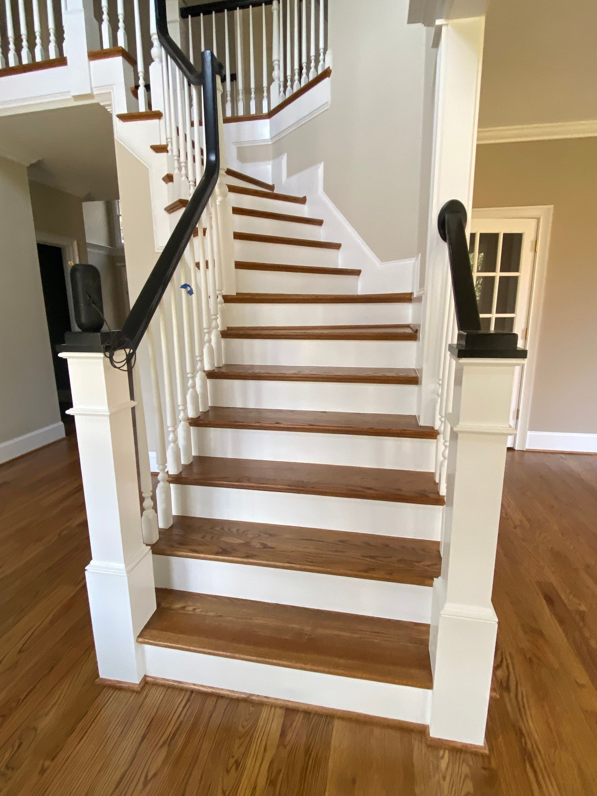 A staircase with wooden steps and a white railing in a house.