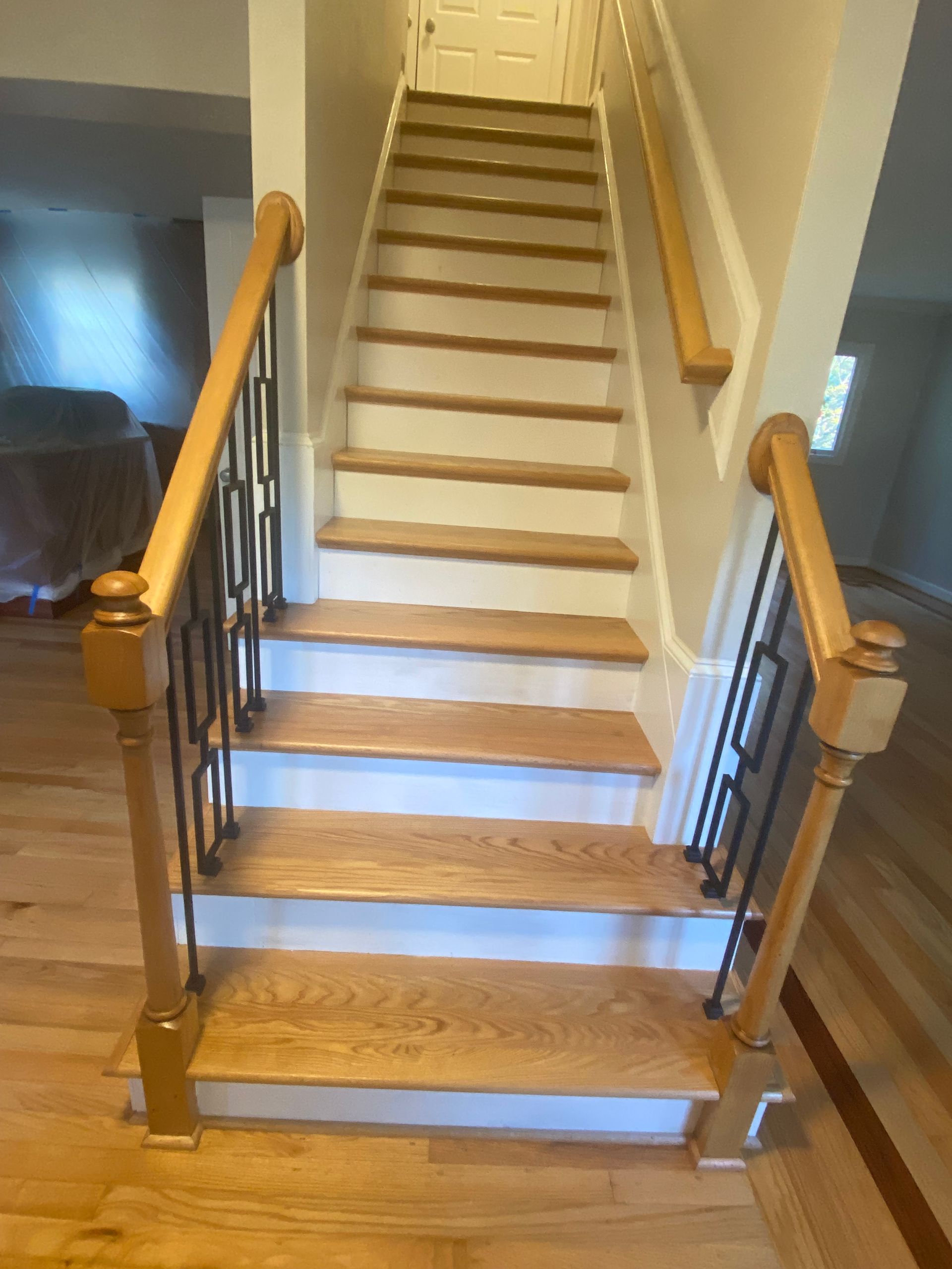 A staircase with wooden steps and a metal railing in a house.