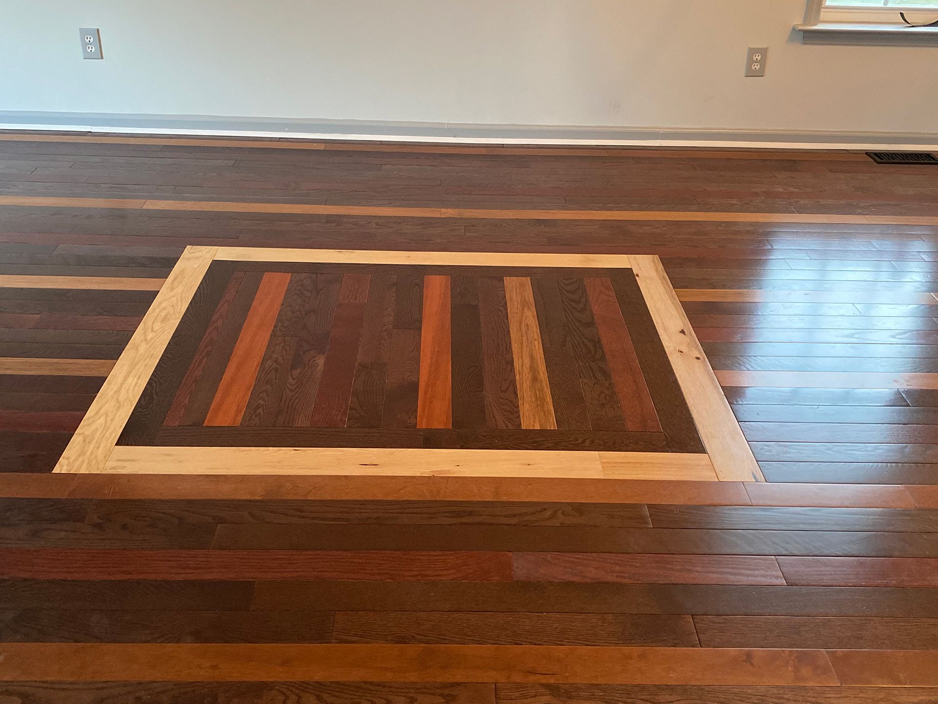 A wooden floor with a square in the middle of it.