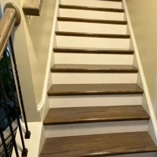 A set of stairs with wooden steps and a white railing.