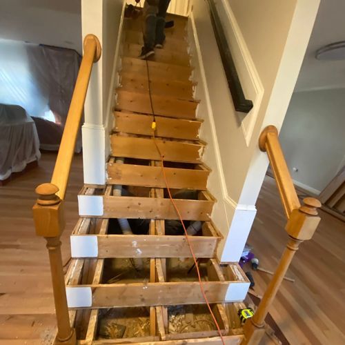 A man is walking up a set of wooden stairs.