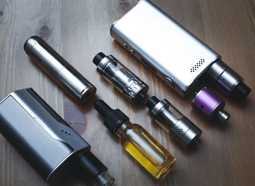 A bunch of electronic cigarettes are on a wooden table