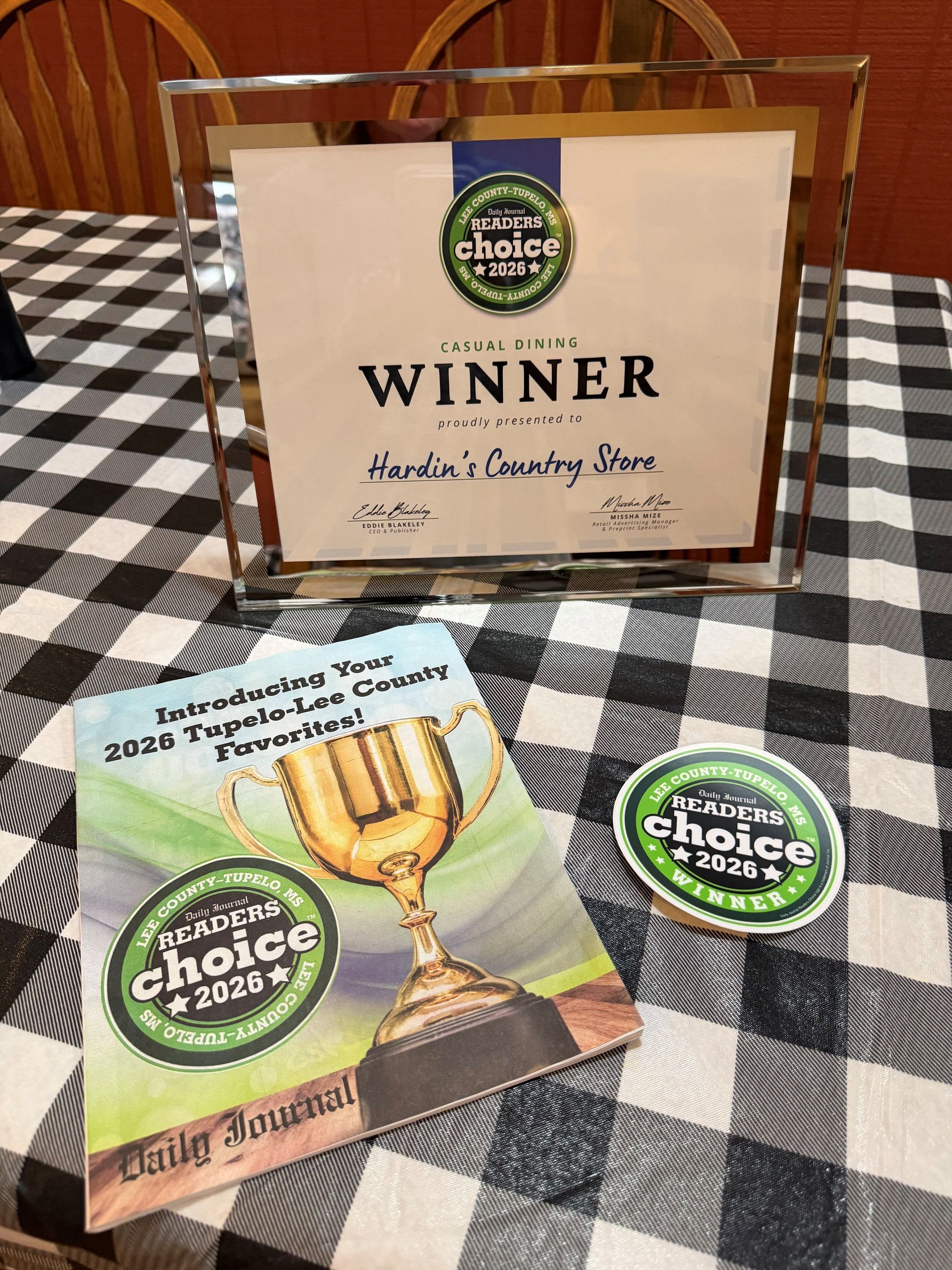 Award plaque and brochure on a checkered tablecloth, celebrating a 2026 choice award.