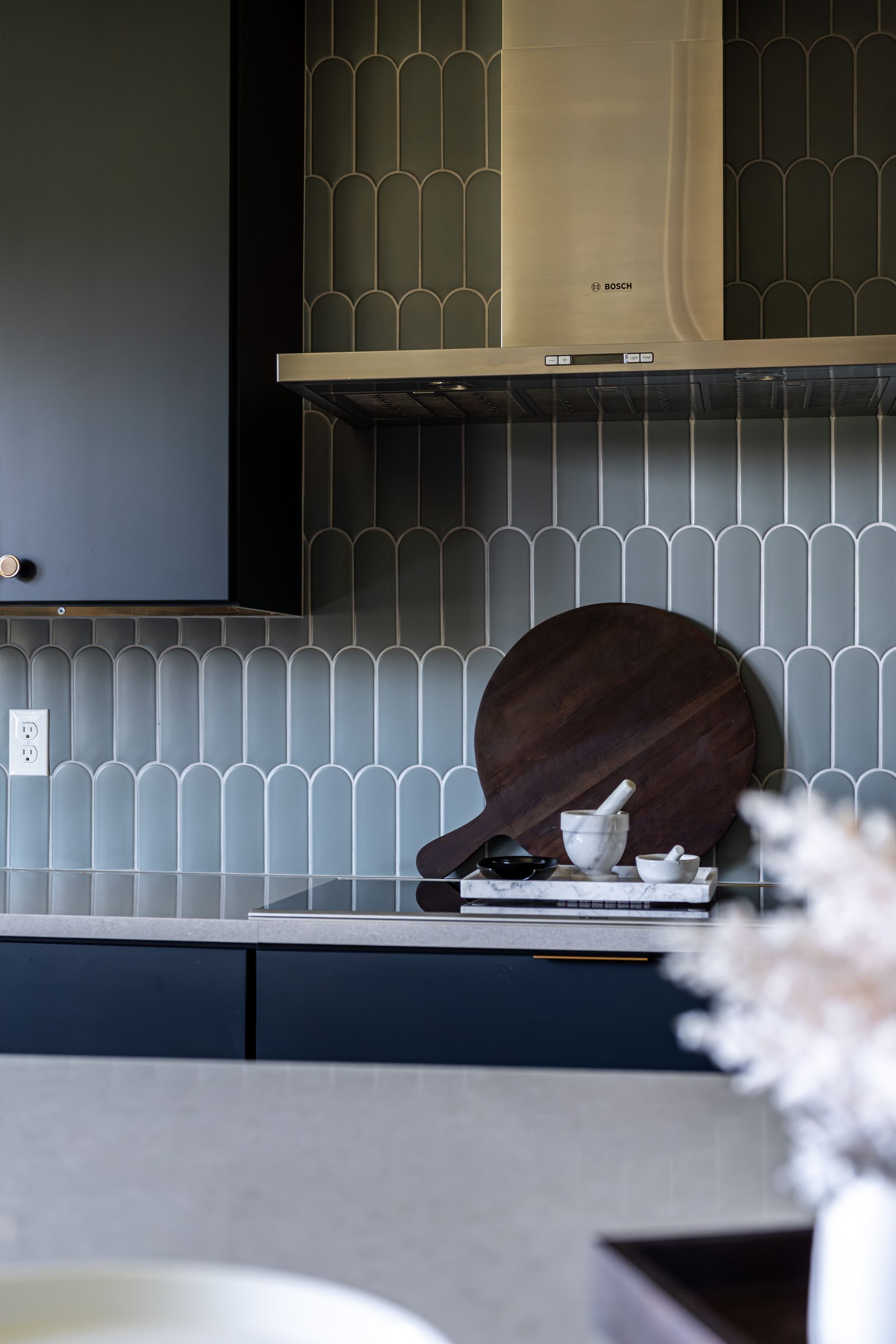 A kitchen with a stove top oven and a cutting board on the counter.