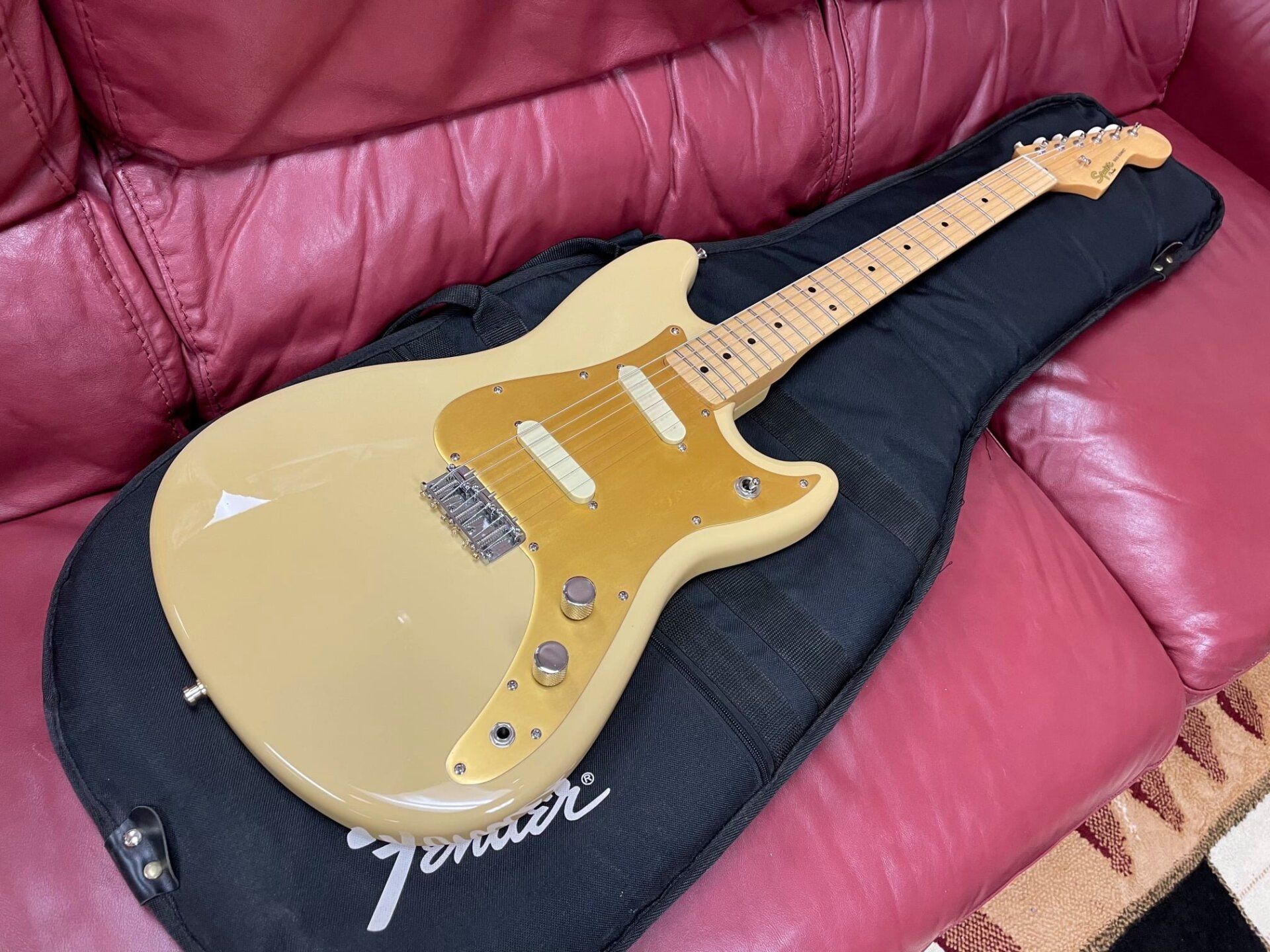 Cream colored electric guitar with case