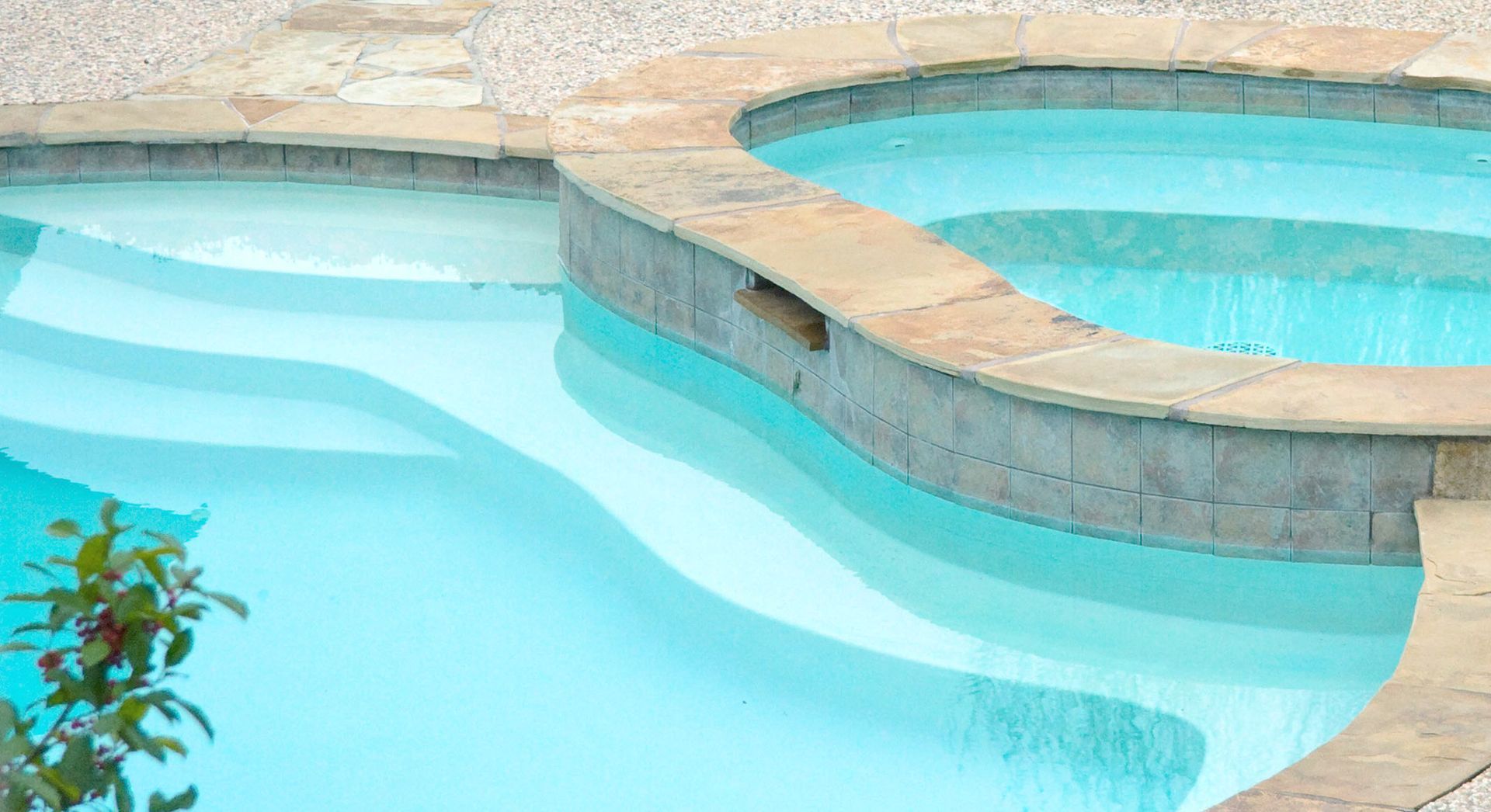 A swimming pool with a hot tub in the middle of it.