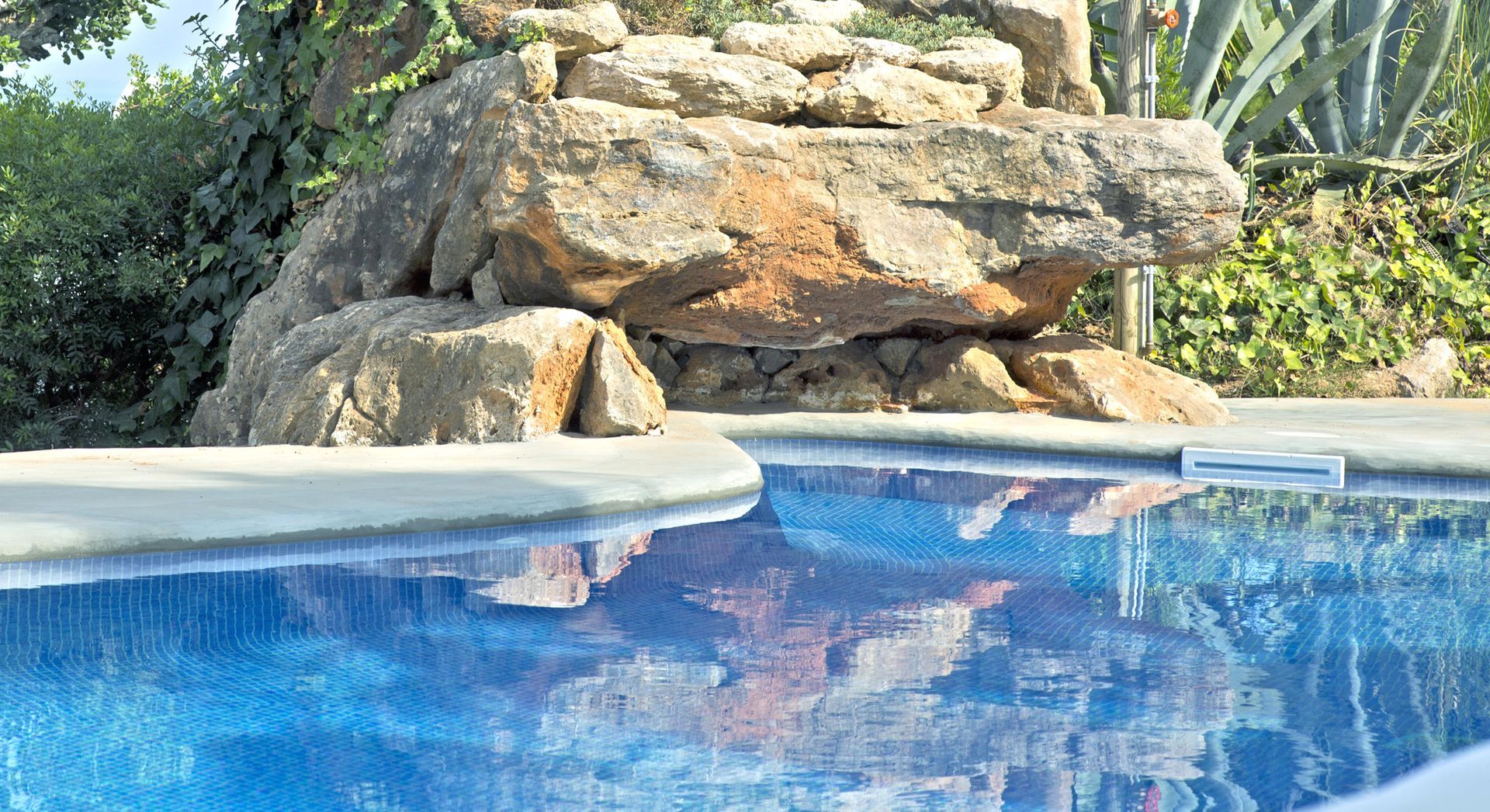 A swimming pool with a waterfall in the background