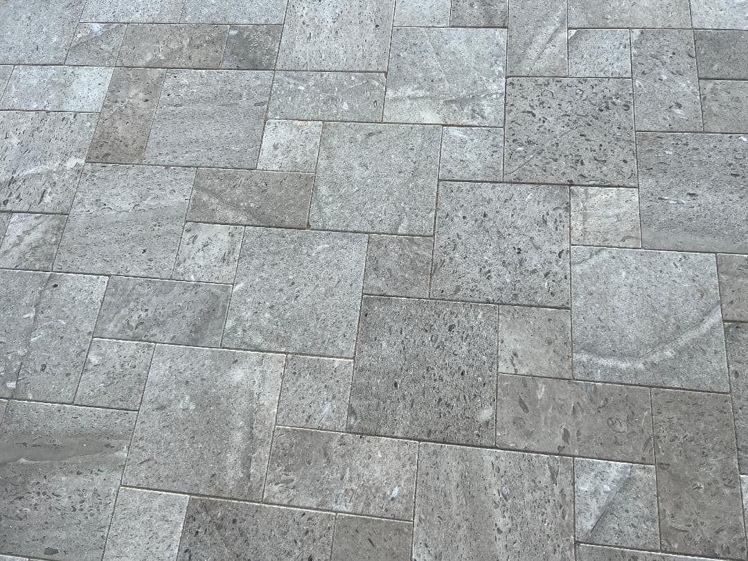 Gray stone tiles arranged in a staggered pattern, providing a textured surface.