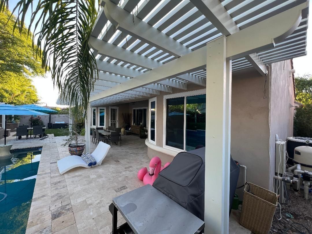 Patio with a pool, grill, and pergola-covered seating area. Sunny backyard.