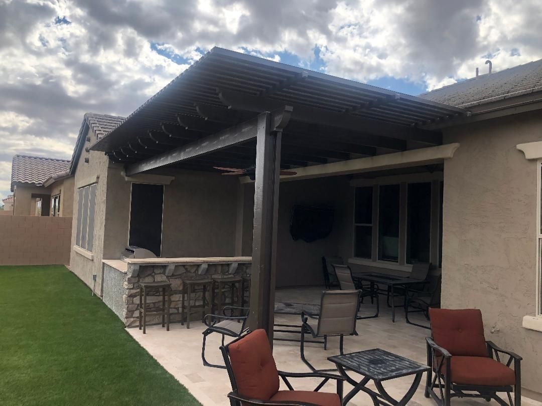 Backyard patio with a pergola, bar, seating, and a TV.