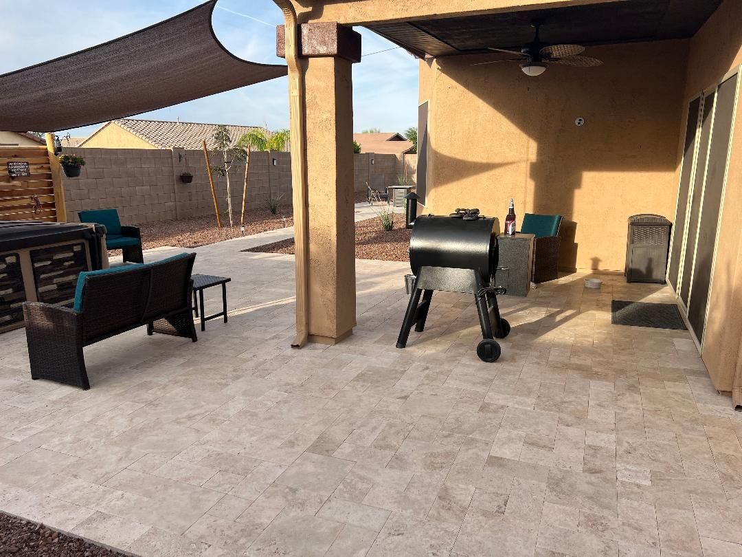 Patio with tan tile floor, shaded area, grill, and seating.
