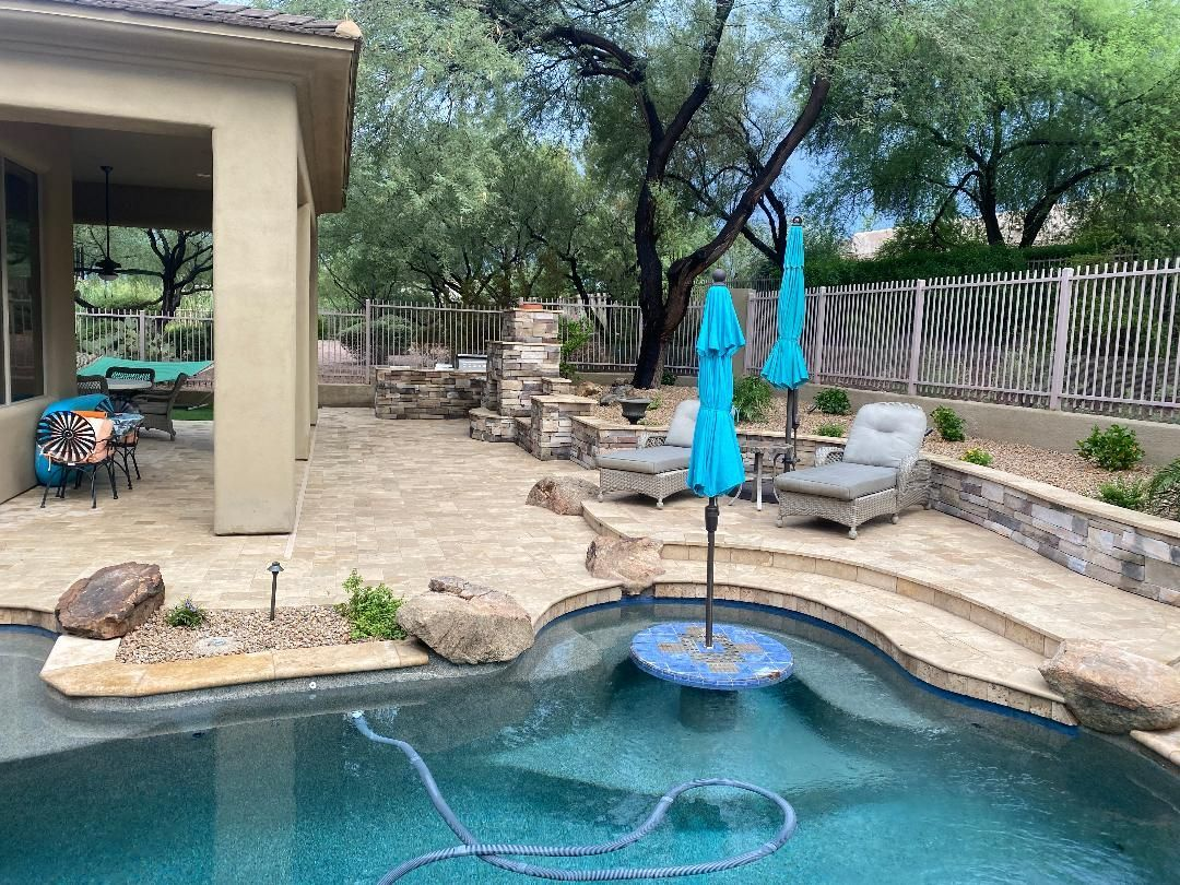 Outdoor patio with swimming pool, lounge chairs, and turquoise umbrellas.