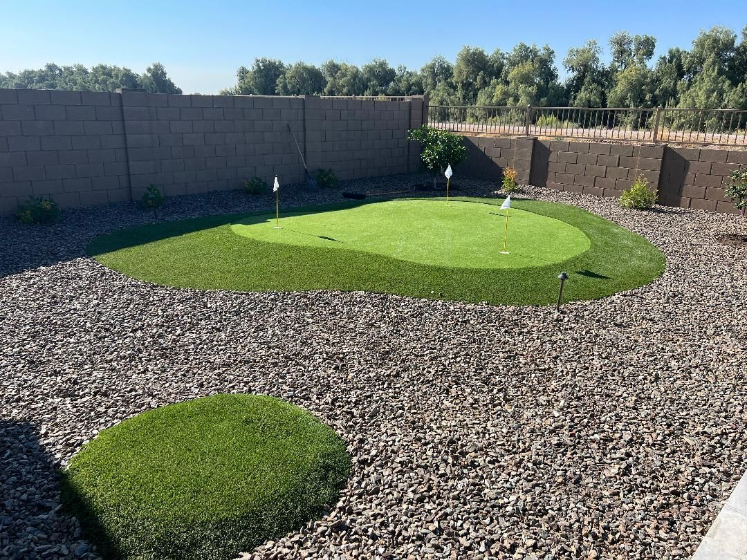 Backyard putting green surrounded by wood chips, with a small circular lawn feature.